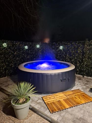 un grand jacuzzi avec de l'eau bleue dans l'établissement Maisonnette Rétro Loc, à Amfréville