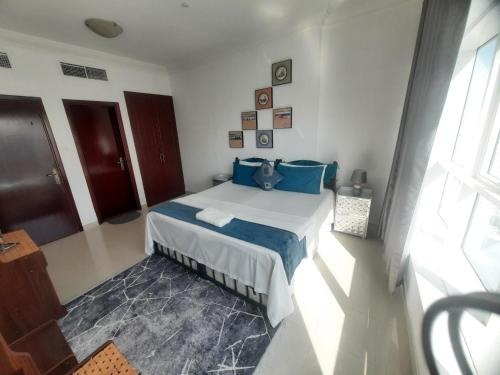 a bedroom with a bed with blue pillows at Private Room at Expo Centre Sharjah in Sharjah