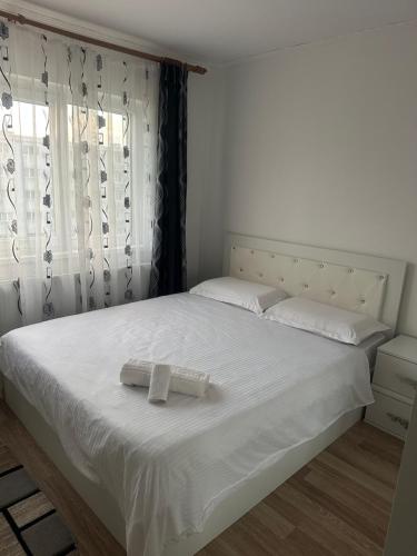 a bedroom with a white bed with two towels on it at Apartament Tudorache Premium in Turceni