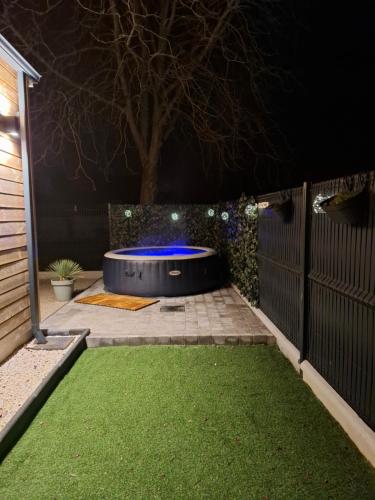 un jardin illuminé la nuit par un frisbee dans l'établissement Maisonnette Rétro Loc, à Amfréville