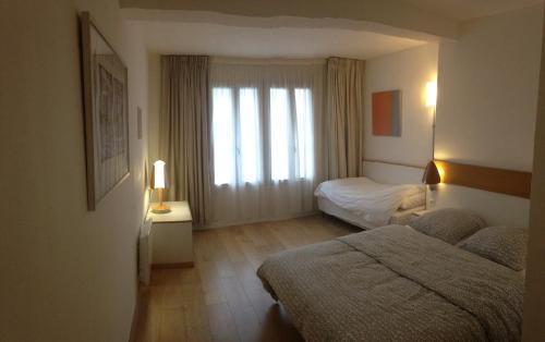 a hotel room with two beds and a window at Chambres Boufflet in Laon