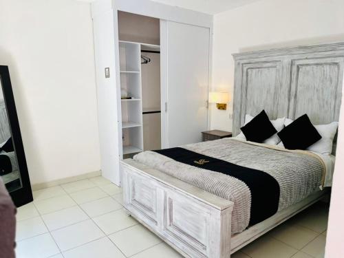 a white bedroom with a large bed with black pillows at 12 VENATOR House Boutique in León
