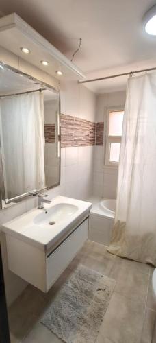 a white bathroom with a sink and a shower at El Ain El Sokhna-Villa at Piacera Resort Seaview in Ain Sokhna