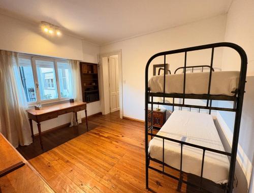 a room with two bunk beds and a desk at Casa LUHA in San Antonio de Areco