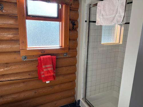 a bathroom with a shower and a red towel at Montana Hill Guest Ranch in Bridge Lake