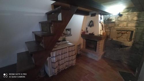 a living room with a staircase and a stone fireplace at Il BORGO DEL VENTASSO in Busana
