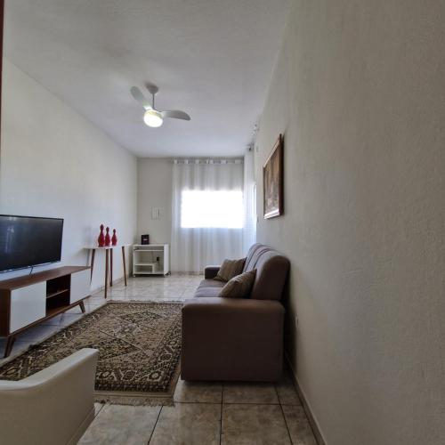 a living room with a couch and a flat screen tv at Refúgio Aura,casa com suíte, wi-fi, garagem e churrasqueira in Aparecida