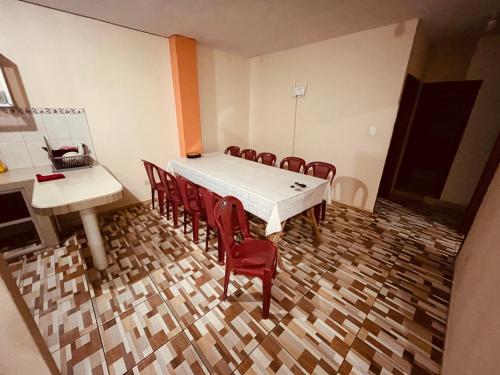 a dining room with a white table and red chairs at Apt 1 in Tena