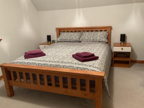 a bedroom with a large wooden bed with two night stands at Taighali Apartment in Aultbea