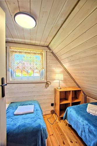 a room with two beds and a window and a table at Dziedziniec Karkonoszy in Podgórzyn