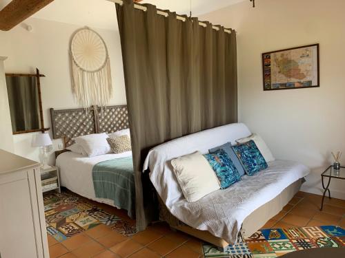 a bedroom with two beds with curtains in it at Chambres d'Hôtes et Gîtes Le Mas Mellou in Orange