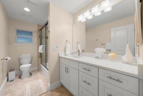a white bathroom with a sink and a toilet at Tahitian Waters in Sanibel