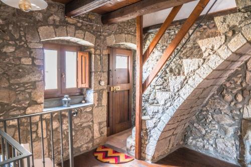 a stone staircase in a house with a stone wall at The Templars Guesthouse in Santu Lussurgiu