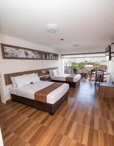 two beds in a room with wooden floors at Centro Recreacional Simbal in Trujillo