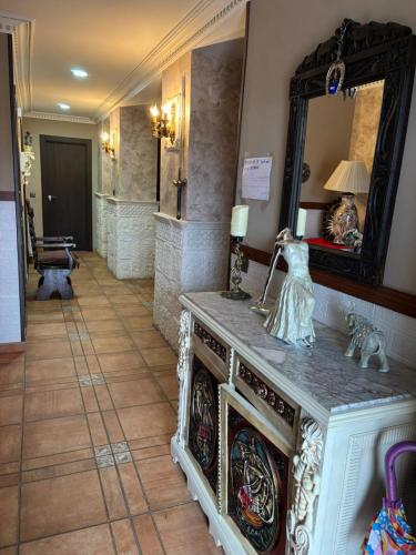 a room with a mirror and a table with a statue at Castillo Valmoral in Burgos
