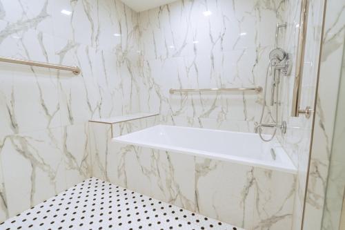 a bathroom with a white sink and marble walls at Holiday Inn Express Hotel & Suites Cocoa Beach by IHG in Cocoa Beach