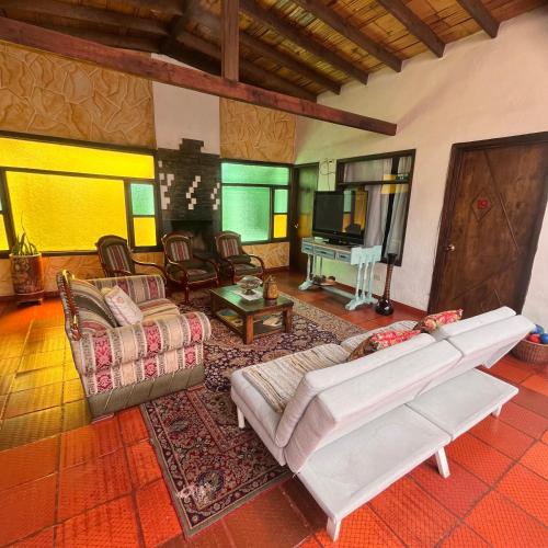 a living room with a couch and a television at Hospedaje La Casona in Tabio