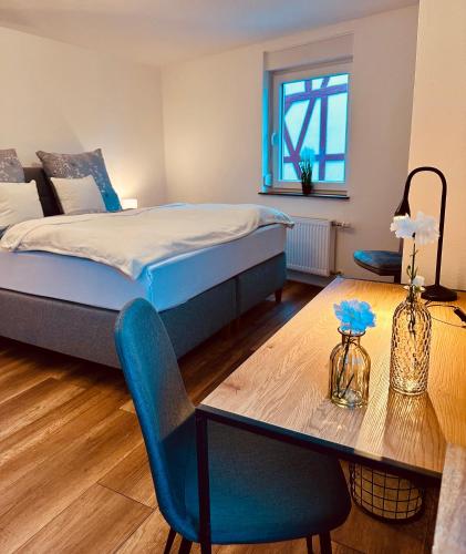 a bedroom with a bed and a table and a bed at Ferienhaus Griede mit 3 Schlafzimmern in Mörsdorf