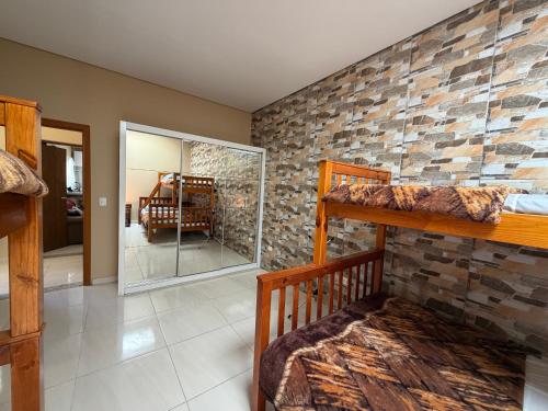 a room with two bunk beds and a stone wall at Recanto da Ivete in São Sebastião
