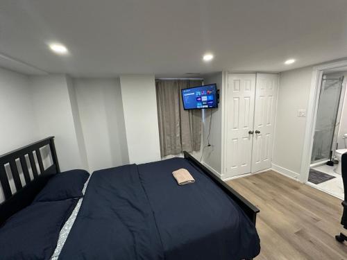 a bedroom with a bed with a tv on the wall at Cozy Basement Studio with Private Bathroom and Kitchen in Vaughan