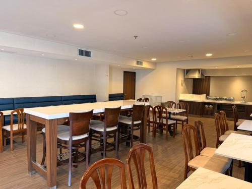 Un comedor con una mesa grande y sillas. en Victoria Inn, en Ciudad Victoria