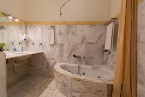 a bathroom with a bath tub and a sink at Villa Odyssey Verde in Dassia