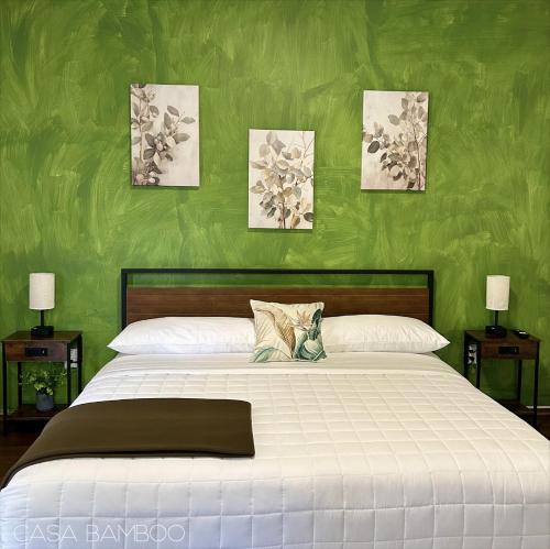 a bedroom with a large bed with green walls at Casa Bamboo in Mexico City