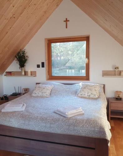 a bedroom with a large bed with a window at Dolina nad Drawa in Przeborowo