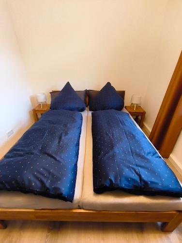 two beds in a room with blue comforter and pillows at Michas FeWo in Bautzen