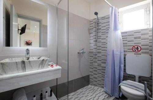 a bathroom with a sink and a toilet and a shower at Pyrgi House 150m from Ipsos Beach with Sea View in Ipsos