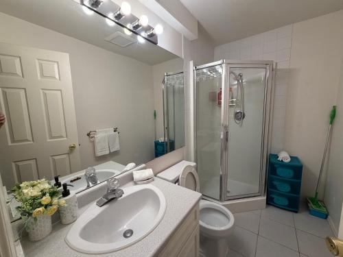 a bathroom with a sink and a shower and a toilet at Lovely suite in Burnaby