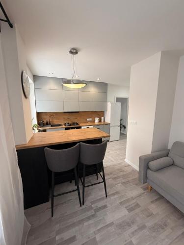 a kitchen with a table and chairs and a couch at Apartament Modrzewia in Elblag