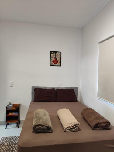 a bed with two pillows on it in a bedroom at Studio com Ar condicionado, Boa Localização, Internet Rápida 2 in Joinville