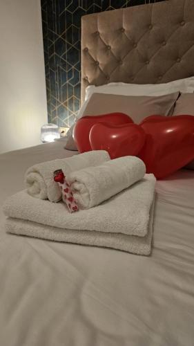a pile of towels on a bed with a red heart at Luxury Opus Osijek - Self Check in, Free Private Parking in Osijek