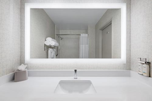 a white bathroom with a sink and a mirror at Holiday Inn Express San Diego - Sea World Area by IHG in San Diego