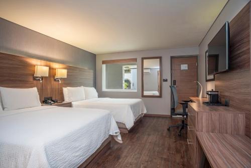 a hotel room with two beds and a television at Holiday Inn Express Morelia by IHG in Morelia
