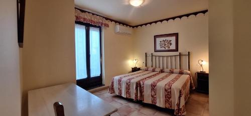 a bedroom with a bed and a large window at La Casa del Regidor Hotel Rural Fermoselle in Fermoselle