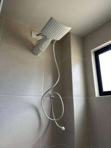 a bathroom with a shower with a light on the wall at Apto vista in Ponta Grossa