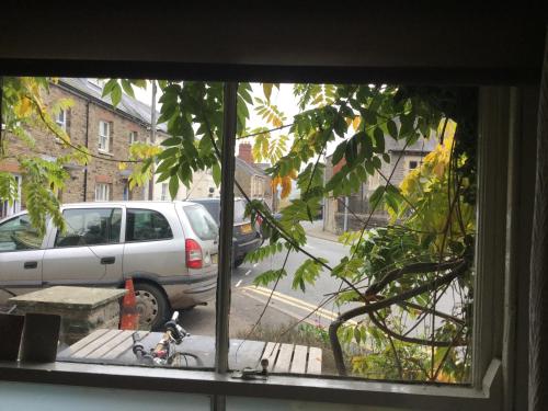 una ventana con vistas a un coche estacionado en una calle en Half Moon House, en Hay-on-Wye