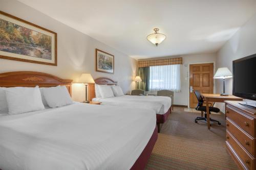 a hotel room with two beds and a desk at SureStay Hotel by Best Western Leesville in Leesville