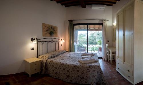 a bedroom with a bed and a large window at Il Gelsomino Bio Agriturismo in Alberese