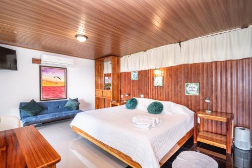 a bedroom with a bed and a blue couch at Corcovado Green Cabin & House in Drake