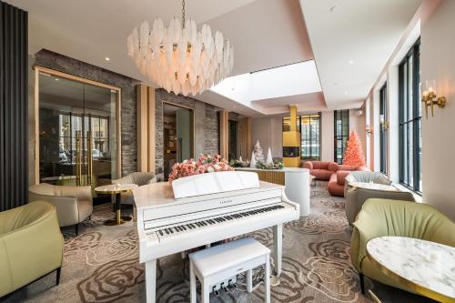a living room with a white piano in the middle at Hotel Port-Royal in Quebec City