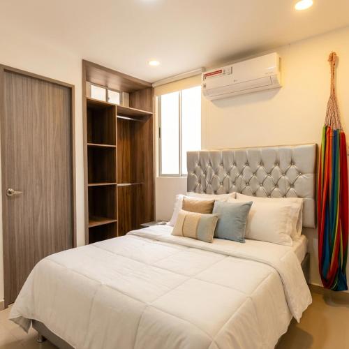 a bedroom with a large white bed and a window at Apartaestudios Galanni in Valledupar