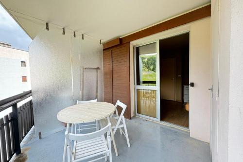 un porche avec une table et des chaises sur un balcon dans l'établissement Appt Confortable in Superdévoluy, à Saint-Étienne-en-Dévoluy