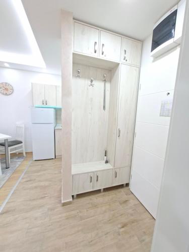 a kitchen with white cabinets and a wooden floor at Apartman TRI KRALJA 4 in Banja Koviljača