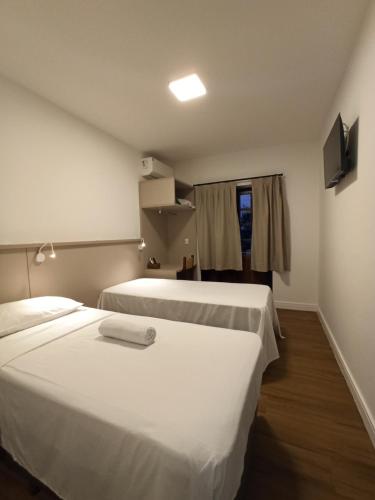 a hotel room with two beds and a window at Hotel Natur Campeche in Florianópolis