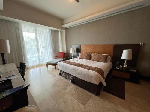 a hotel room with a large bed and a desk at luxury 2bed condo in Nuevo Vallarta