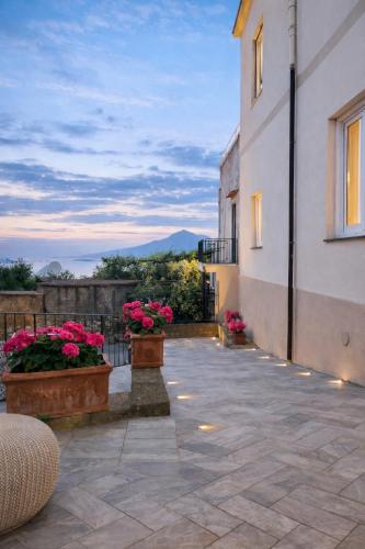 a patio with flowers and a building at L'antica Pigna Chateau in Vico Equense