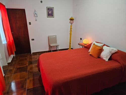 a bedroom with a red bed and a table and chair at Posada Oporto in La Rioja